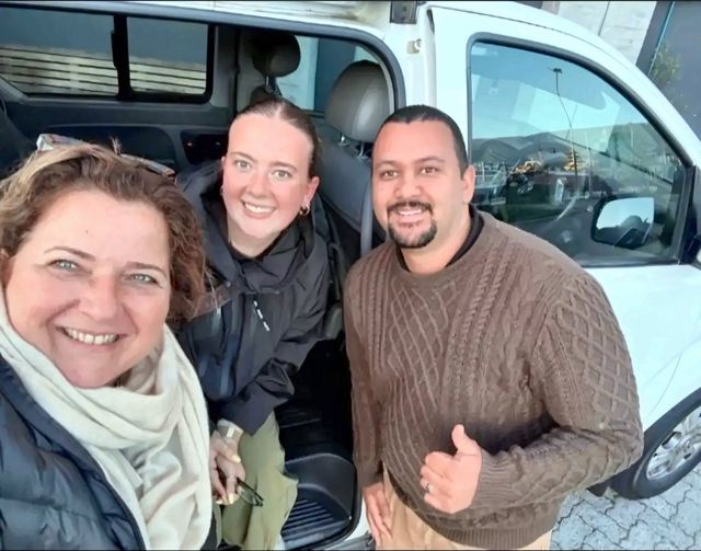 Happy guests beside the white van